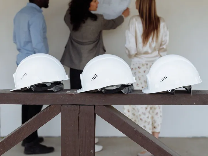Casques de chantier — l’équipe étudie les plans derrière