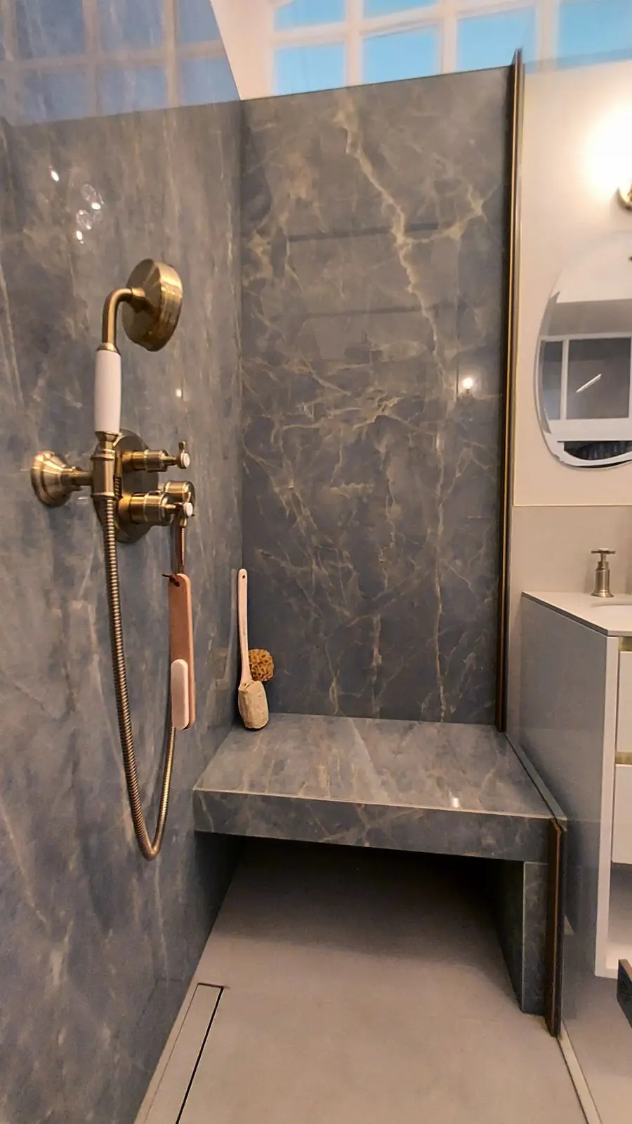 Douche avec banquette intégrée, robinetterie dorée