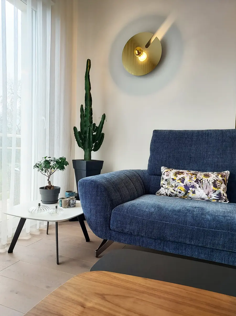 Canapé tissu chenille bleu, applique grand disque dorée et ambiance cosy