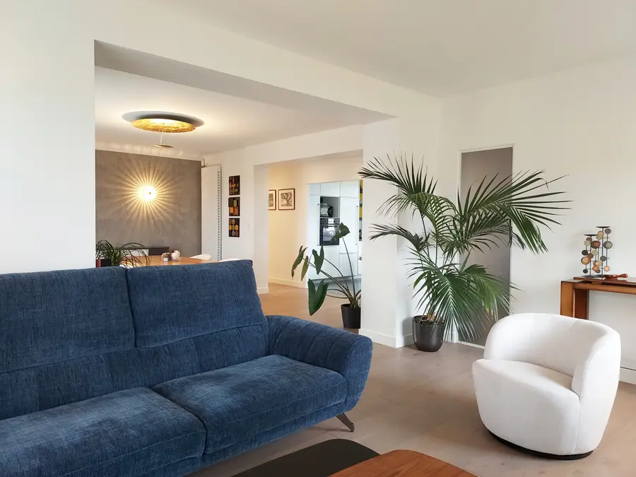 Grand espace décloisonné sur parquet teinté chêne grisé chaud vue sur cuisine